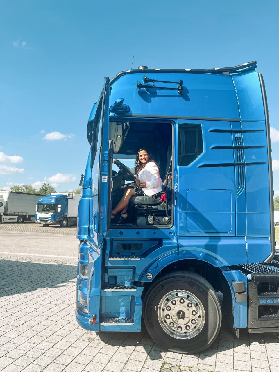 Monisha Anthony sitting in a blue MAN truck