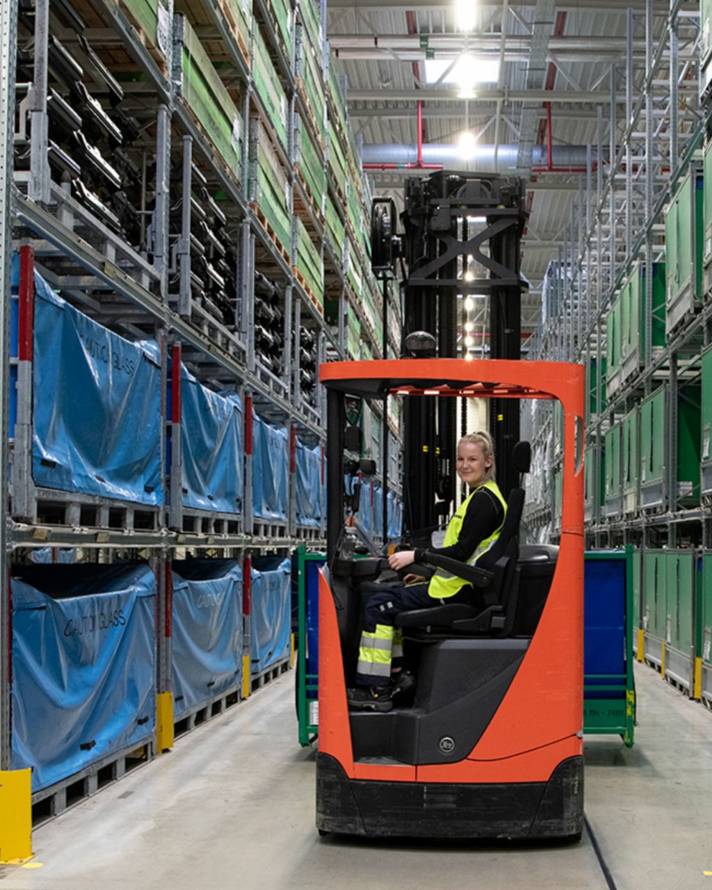 Forklift in a large warehouse Forklift transports parts in a large warehouse