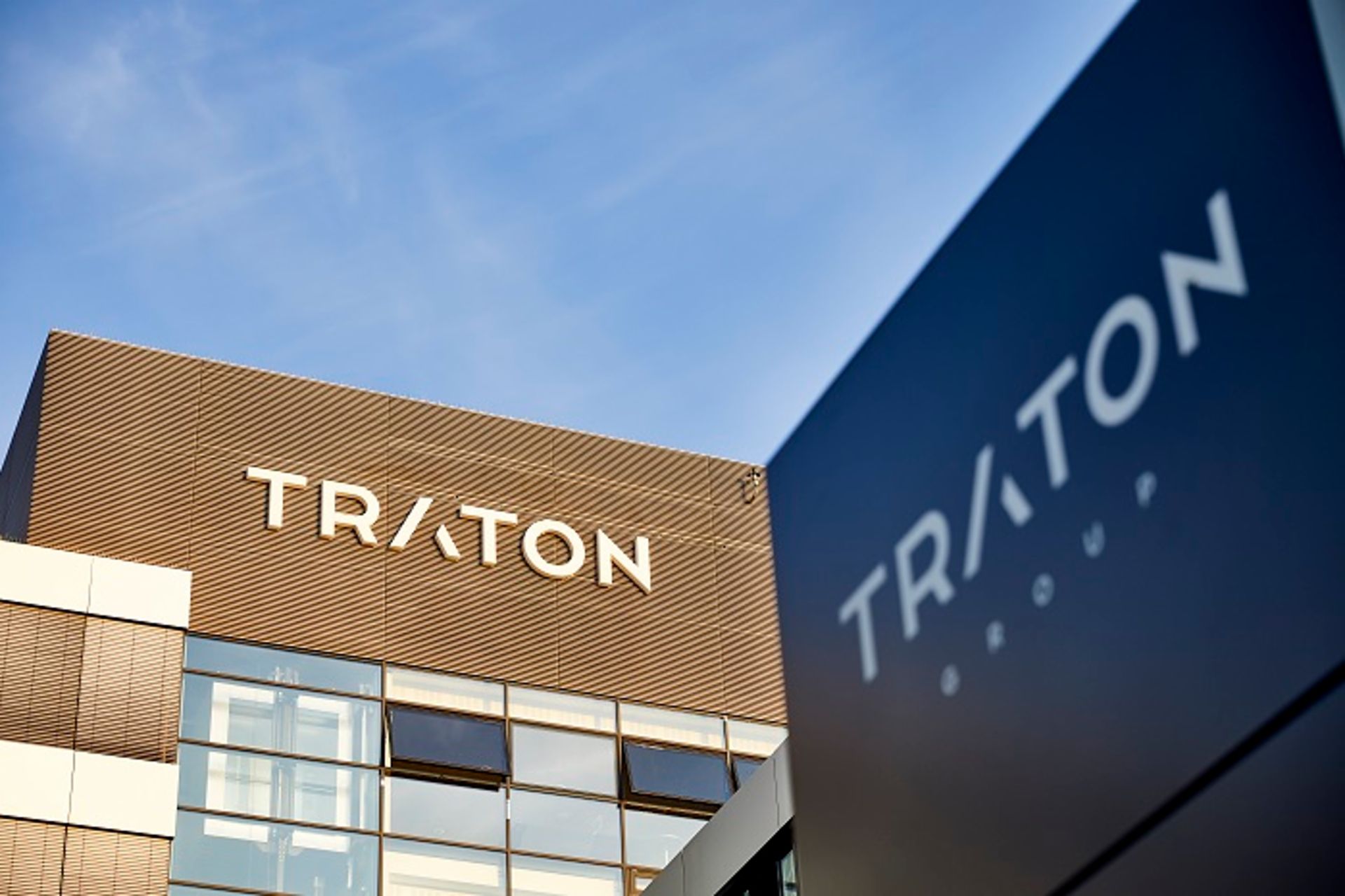 Photo of TRATON building with the logo on the wall on a sunny day
                     