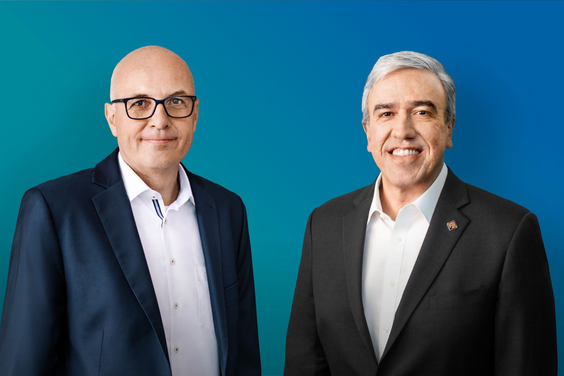 Image of Matthias Gründler (CEO TRATON SE, left) and Persio Lisboa (CEO Navistar Inc., right) in front of a blue background