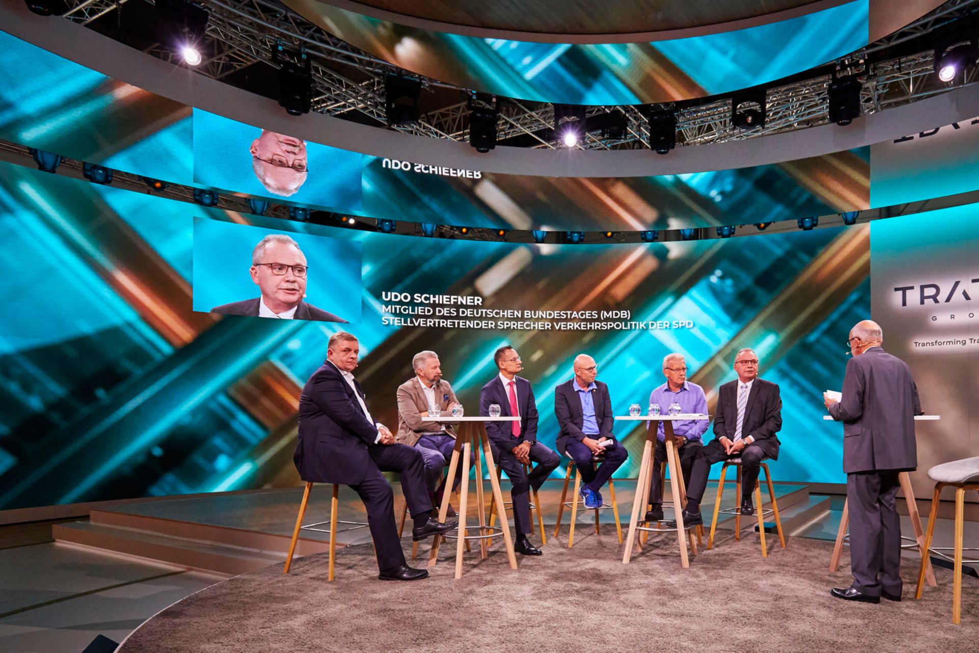 7 men sit at two tables during a roundtable discussion at TRATON during the IAA 2018.