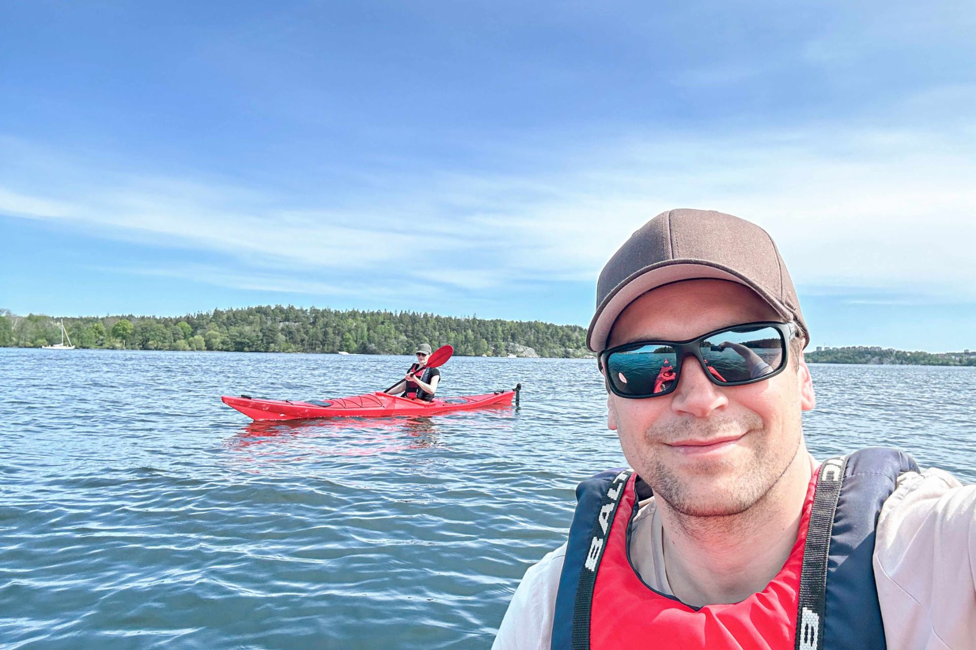 Selfie von Philipp Lassernig auf dem Mälarensee. Im Hintergrund eine Person im Kajak.